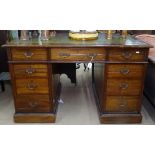 An Edwardian mahogany twin-pedestal writing desk, with inset leather skiver and fitted drawers,