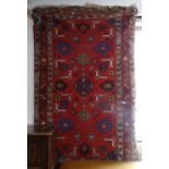 A red ground Afghan rug with symmetrical decoration, 200cm x 120cm