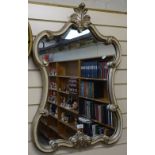 A silvered shaped-edge wall mirror in plaster frame, 34.5"