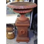 An Antique cast-iron fluted urn, with egg and tongue decoration, on a stepped pedestal, with