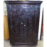 An 18th century oak corner hanging cupboards, with chip carved panel door, W74cm