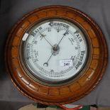 A carved oak-cased aneroid barometer, diameter 13"