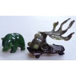 A carved Oriental jade fish on fitted stand, length 3.5" overall, and a carved green-stone bear with