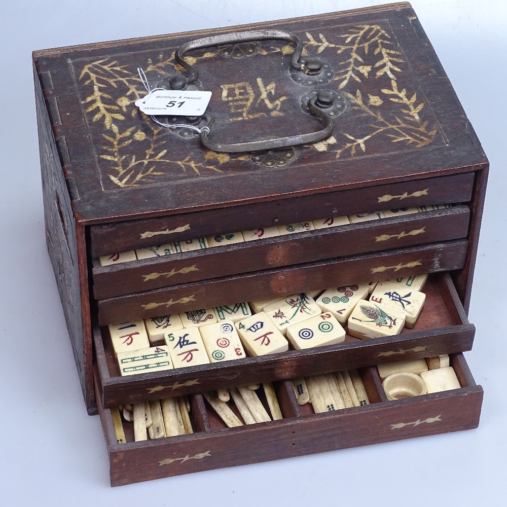 A Chinese bone and bamboo Mahjong set in decorative wooden cabinet, length 9.75"