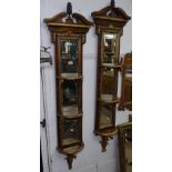 A pair of Antique style mahogany and gilt bevelled-edge mirrors of narrow form, with bow-front