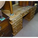 A modern polished pine twin-pedestal writing desk, with 9 short fitted drawers, L155cm