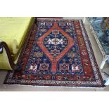 A red ground wool Beluchi rug, with symmetrical pattern, 205cm x 143cm