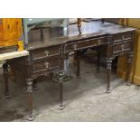 A 1920s oak writing desk, with 5 fitted drawers, on carved turned legs, W152cm