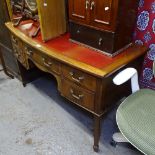 An Edwardian bow-front knee-hole writing desk, with 5 crossbanded short drawers, square tapered legs