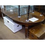 A late Victorian mahogany oval wind-out dining table, with 2 spare leaves, raised on square