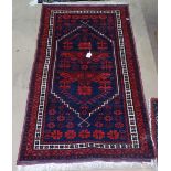 A small red ground Beluchi rug, 135cm x 77cm