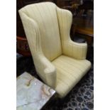 An Antique upholstered wingback armchair, on carved cabriole legs