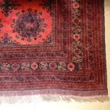 A large red ground Turkemon design carpet, with symmetrical pattern, 320cm x 250cm