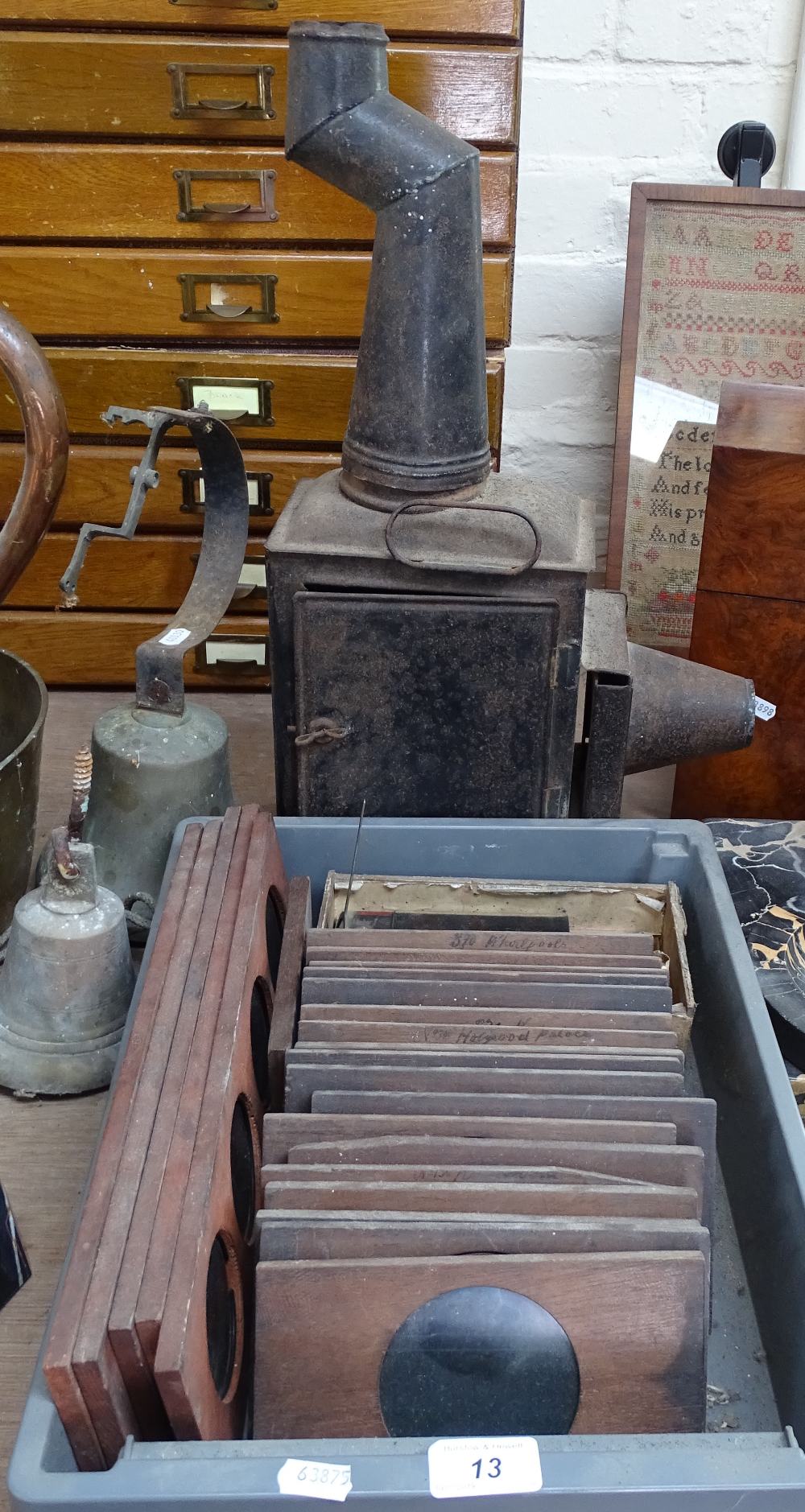 A tinplate magic lantern, and a quantity of coloured glass slides depicting animals, ships etc