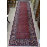 A red ground Turkish design wool runner, 320cm x 85cm