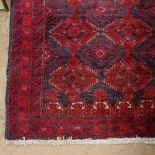 A red ground Turkemon design rug, 183cm x 97cm