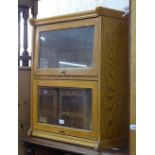 An oak bookcase with 2 glazed rise and fall doors, W58cm