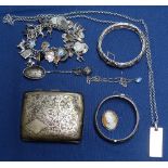 A box containing an engraved silver cigarette case, a silver and enamel charm bracelet, a filigree
