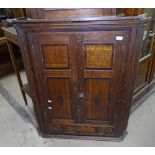 A George III oak corner hanging cupboard, with 2 panelled doors, and drawer under, W100cm