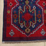 A red ground Beluchi rug, 135cm x 80cm