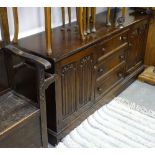 A reproduction oak dresser base, with 3 short drawers and linenfold panelled cupboards