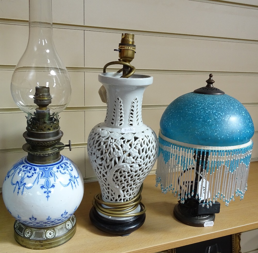 A blue and white oil lamp, a pierced table lamp, and another with fringed shade - Image 2 of 2