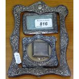 A rectangular embossed silver frame, 2 small silver-fronted photo frames, and a small silver-cased