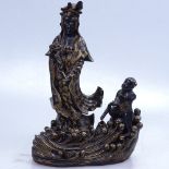 A Chinese gilded and black glaze ceramic figure of Buddha, on wave design base, height 24cm