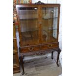 A burr-walnut display cabinet on stand, 2 bevelled glazed doors with drawers under, raised on
