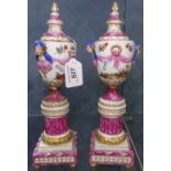 A pair of German porcelain embossed and painted urns and covers on stands, 10.75"