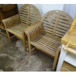 A pair of teak arch-top garden elbow chairs