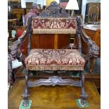 An Antique Italian carved walnut X-framed chair, with cherub and lion mask decoration