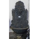 A cast-iron embossed lion mask wall-mounted water fountain, L80cm
