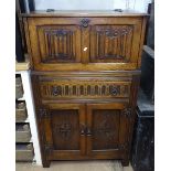 A linenfold panelled and carved oak cocktail cabinet
