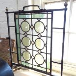 Antique wrought-iron framed firescreen, with leadlight glass panels and brass finials, height 28.5"