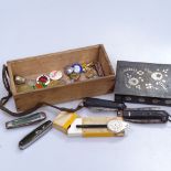 A tin, pocket knives, badges and medallions