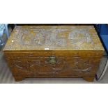 An Oriental camphorwood blanket chest, with all over relief carved decoration, W94cm, H51cm