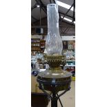 A Victorian wrought-iron adjustable standard lamp, with oil lamp fitting