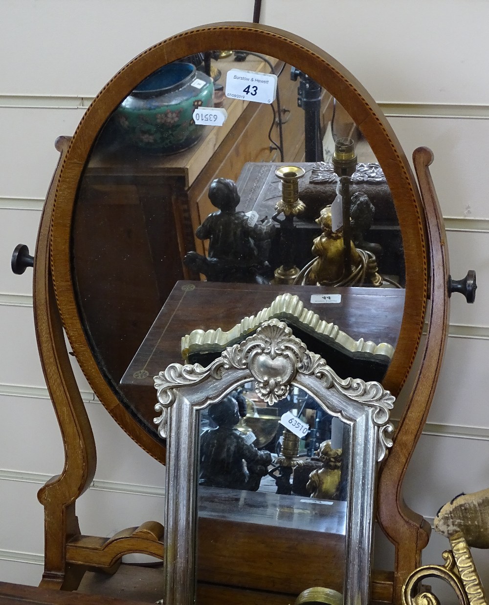 An Edwardian inlaid mahogany oval swing toilet mirror, another, and a gilt composition wall bracket