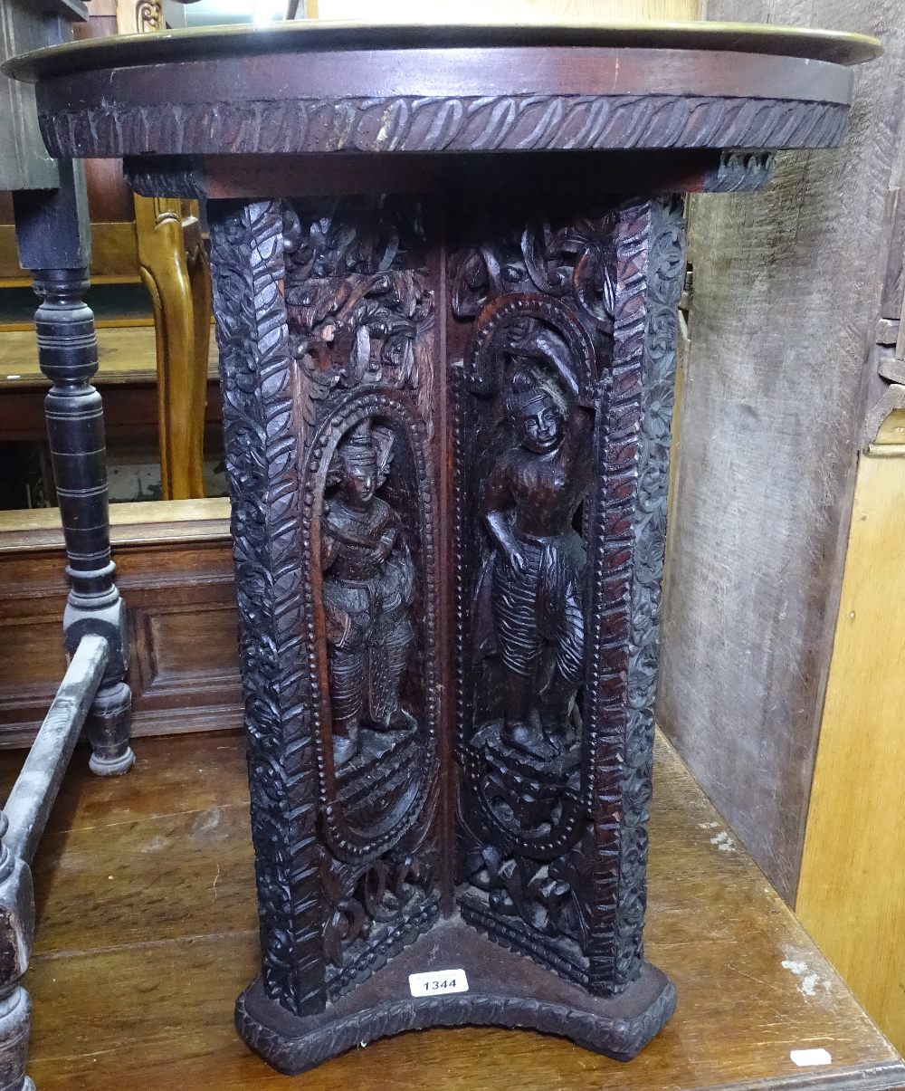 An Indian carved hardwood circular table, with engraved brass top, 51cm