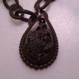 A Victorian carved vulcanite pendant necklace, with relief carved grapevine decoration and oval link