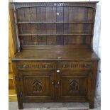 An oak dresser with open plate rack, fitted drawers and cupboards under, on stile legs, W128cm,