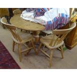 A modern circular polished pine kitchen table, together with 4 matching beech kitchen chairs