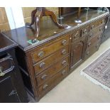 An 18th century oak dresser base, with 10 fitted drawers, and arch panelled cupboard door to the