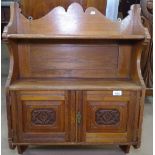 An Edwardian oak hanging cabinet with 2 carved panelled doors, W61cm