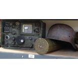 A cannon shell, a steel helmet, and a military radio