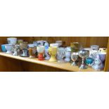 A shelf of Vintage glass, metal, and porcelain egg cups