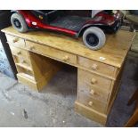 A polished pine twin-pedestal writing desk, with 9 short drawers, W120cm