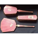 A 3-piece pink enamel silver-mounted dressing table brush and mirror set