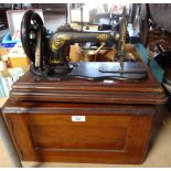 An early Singer sewing machine in wooden case